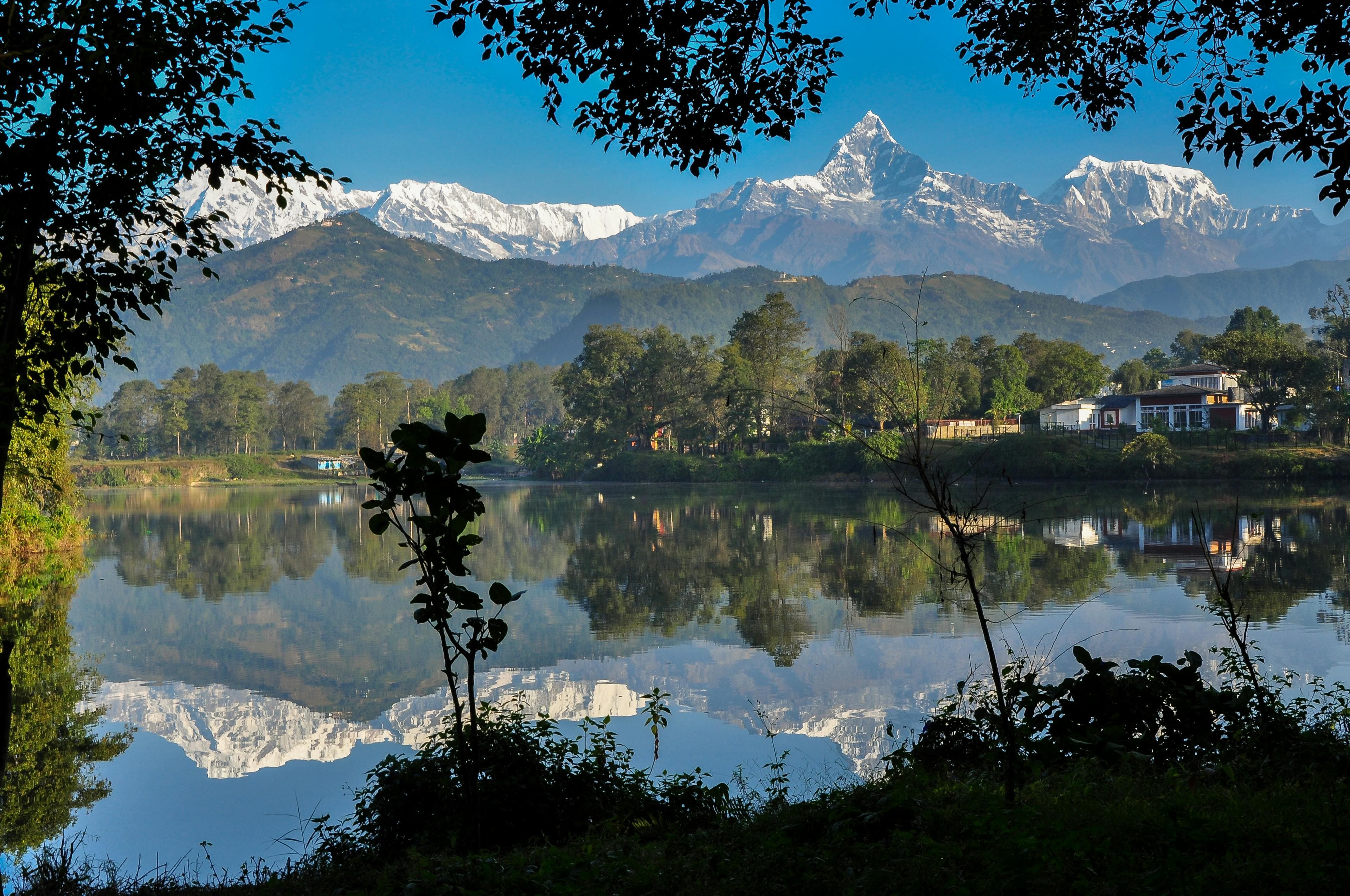 Coffee cup on wooden table overlooking Phewa Lake and Annapurna mountains Pokhara